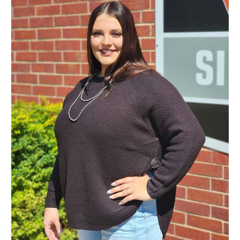 black knit sweater with high slit sides and a buffalo concho at the top of each slit. 