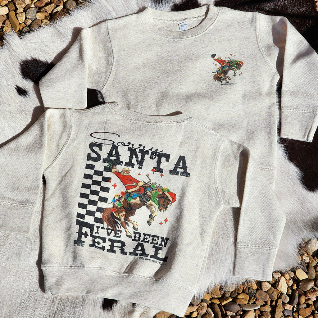 Heather grey sweatshirt with Santa riding a bucking horse and saying of " Sorry Santa I've been Feral "