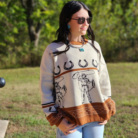 Cream and brown over sized sweater with vintage cowboys roping  on it 