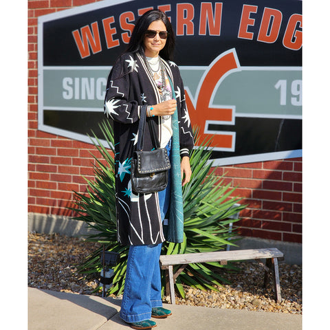 Black cardigan with white horse and star pattern with turquoise accents. 