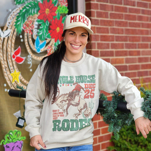 tan sweatshirt with bucking horse and rider with read shirt  Has a Christmas theme with Jingle Horse and Christmas lights 