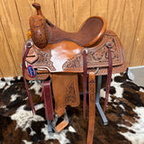 Left view of the saddle showing the flower tooling and the antique reddish finish