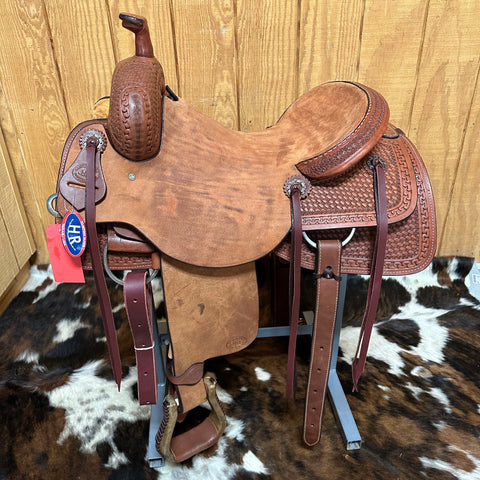 Left view of the saddle showing the silver conchos and the roughout seat and fenders