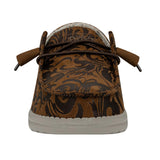 A frontal view of a brown HEYDUDE shoe. The shoe features a western-inspired floral pattern throughout.