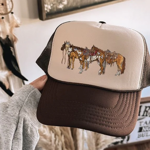 Chocolate Brown trucker hat with Tan front and horses saddled on  the front. 