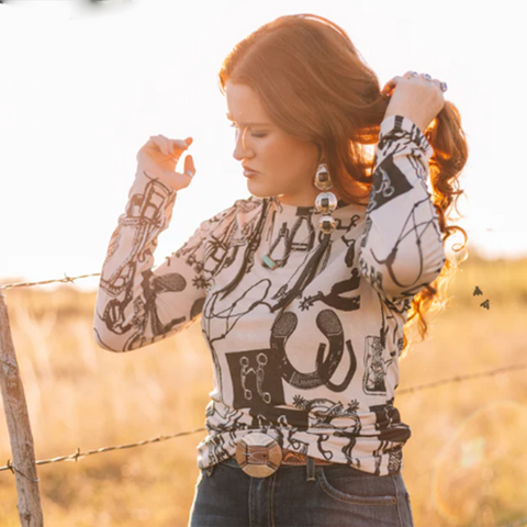 black and white fitted shirt adorned with bits, spurs, and horse tack